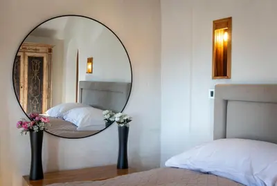 a mirror in a bedroom with two beds and flowers at Royal Casa in Belgrade