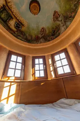 a bedroom with a ceiling with windows and a bed at Royal Casa in Belgrade