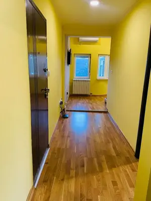 an empty hallway with yellow walls and a wooden floor at Zemun Belgrade Apartment in Belgrade