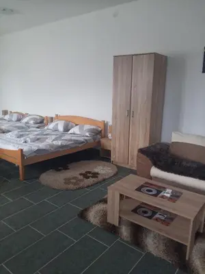 a bedroom with two beds and a coffee table at Stan na dan Platičevo in Platičevo