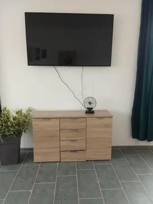 a flat screen tv on top of a wooden dresser at Stan na dan Platičevo in Platičevo
