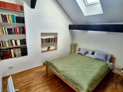 a bedroom with a bed in a room with bookshelves at Roof in Belgrade