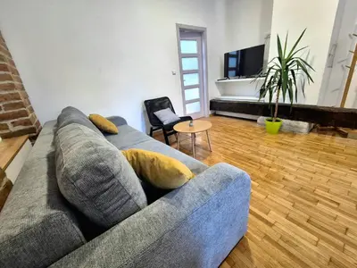 a living room with a gray couch and a table at Roof in Belgrade
