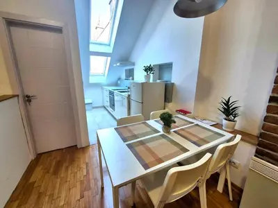 a kitchen and dining room with a table and chairs at Roof in Belgrade