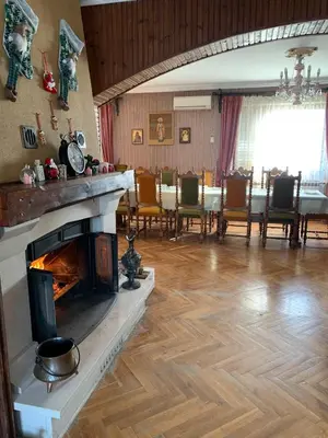 a living room with a fireplace and a table with chairs at Kosmaj Residence in Dučina