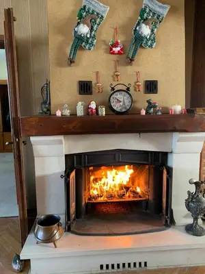 a fireplace with christmas ornaments and a clock at Kosmaj Residence in Dučina