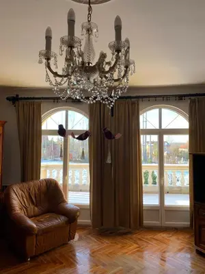 a living room with a chandelier and large windows at Kosmaj Residence in Dučina