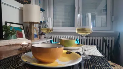 a table with a bowl and glasses of wine at CoCo Studio Bright & Stylish Apartment in Central Belgrade in Belgrade