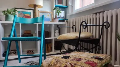 a blue chair sitting next to a bed in a room at CoCo Studio Bright & Stylish Apartment in Central Belgrade in Belgrade