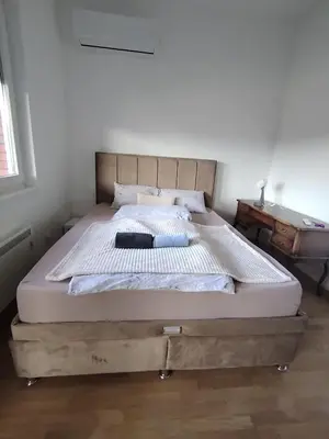 a bedroom with a large bed with a wooden frame at Apartman Gala Beograd in Belgrade