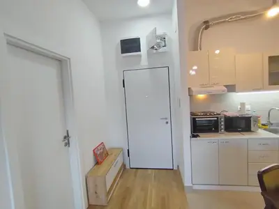 a kitchen with a white door and a kitchen with a stove at Apartman Gala Beograd in Belgrade