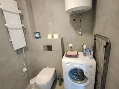 a bathroom with a washing machine and a toilet at Apartman Gala Beograd in Belgrade