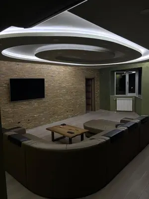 a room with a table and chairs and a tv at Luxurious apartment with a jaccuzi and 4 bedrooms in Belgrade