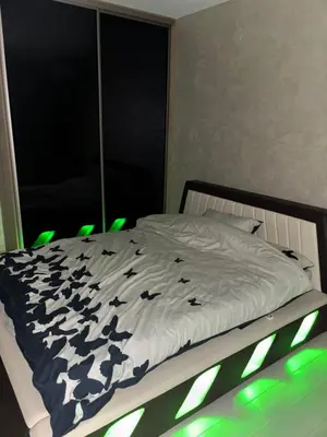 a bedroom with a bed with green lights on it at Luxurious apartment with a jaccuzi and 4 bedrooms in Belgrade