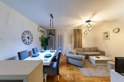 a living room with a dining table and a couch at Apartment SIX - free parking in Belgrade