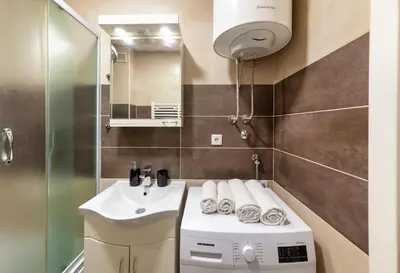 a bathroom with a sink and a washing machine at Apartment SIX - free parking in Belgrade
