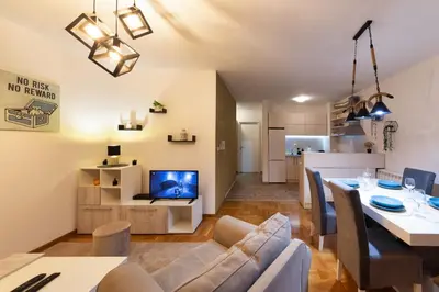 a living room and dining room with a table and a couch at Apartment SIX - free parking in Belgrade
