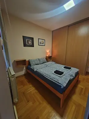 a bedroom with a bed with a blue comforter at Flat near Belgrade Waterfront in Belgrade