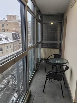 a balcony with a table and chairs and windows at Flat near Belgrade Waterfront in Belgrade