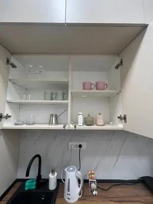 a kitchen with white shelves with pots and pans at Saint Mark in Belgrade
