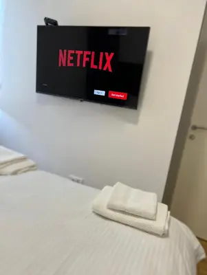 a tv on a wall above a bed in a room at Saint Mark in Belgrade