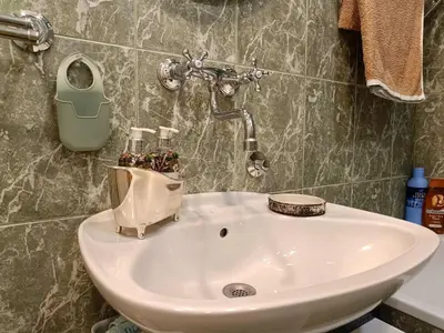 a bathroom with a sink with a soap dispenser on it at Beolight Apartment in Belgrade