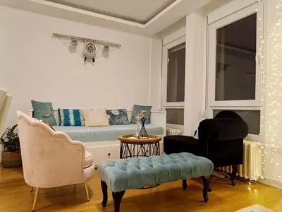 a living room with a couch and two chairs at Beolight Apartment in Belgrade