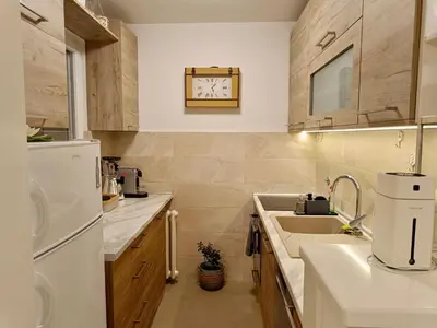 a kitchen with a sink and a clock on the wall at Beolight Apartment in Belgrade