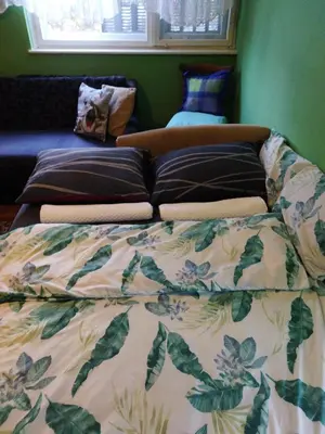 a bed with pillows on it in a bedroom at Grin in Zemun Polje