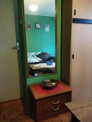a mirror on a dresser in a room with a bed at Grin in Zemun Polje