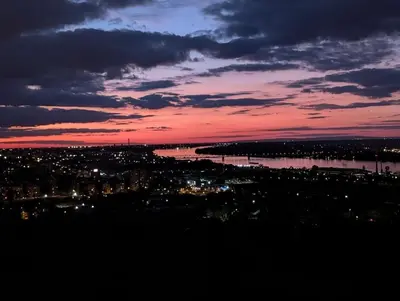 a sunset with a city and a body of water at Luxury Getaway with Comfort! in Belgrade
