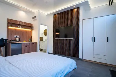 a bedroom with a large bed and a kitchen at Atelier in Belgrade