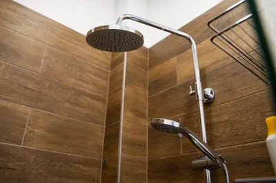 a shower in a bathroom with a wooden wall at Atelier in Belgrade