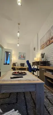 a living room with a table and a couch at Avalavanda Slavija in Belgrade