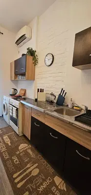 a kitchen with a sink and a clock on the wall at Avalavanda Slavija in Belgrade