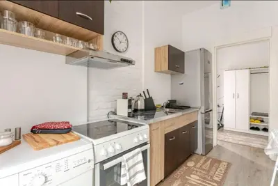 a kitchen with a stove and a clock on the wall at Avalavanda Slavija in Belgrade