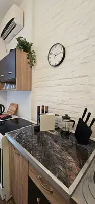 a kitchen with a clock on the wall and a counter at Avalavanda Slavija in Belgrade