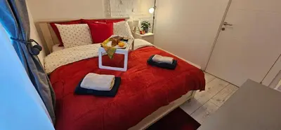a bedroom with a red bed with a teddy bear on it at Avalavanda Slavija in Belgrade