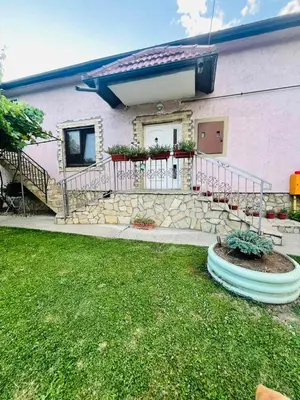 a house with a fence and a grass yard at Surčin Grape Vine Apartments in Surčin