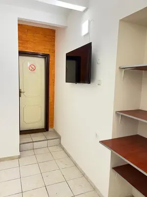 a hallway with a door and a television on a wall at Bed and Shower Alone in Belgrade