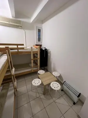 a room with a bunk bed and a table and chairs at Bed and Shower Alone in Belgrade
