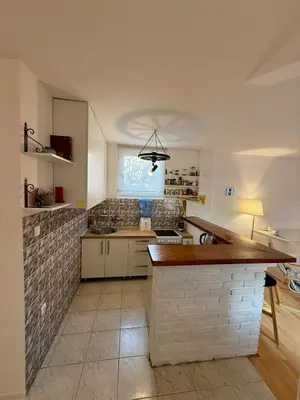 a kitchen with a counter and a brick wall at The White Nest Loft in Belgrade