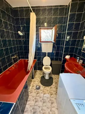 a bathroom with a red tub and a toilet and a sink at The White Nest Loft in Belgrade
