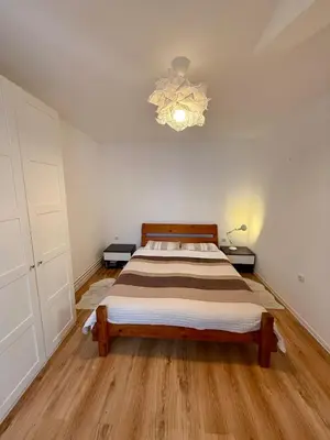 a bedroom with a bed and a chandelier at The White Nest Loft in Belgrade