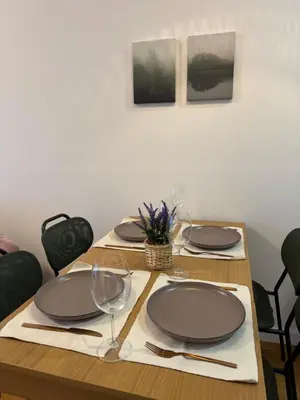 a wooden table with plates and wine glasses on it at Woodstar Apart in Belgrade