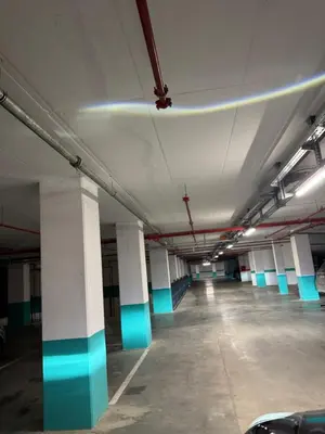 an empty parking garage with blue and white columns at Woodstar Apart in Belgrade