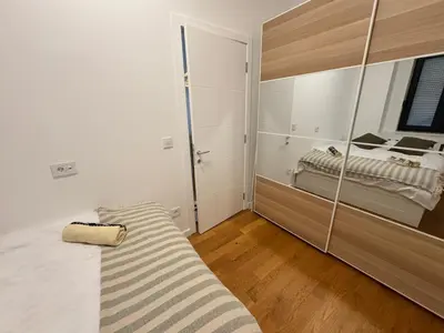 a bedroom with a bed and a large mirror at Woodstar Apart in Belgrade