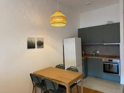 a kitchen with a table and chairs and a refrigerator at Woodstar Apart in Belgrade