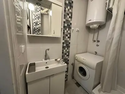 a small bathroom with a sink and a washing machine at City Centre Retreat Pionir Apartment in Belgrade