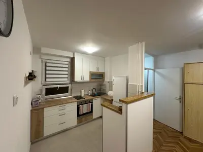 a kitchen with white cabinets and a refrigerator at City Centre Retreat Pionir Apartment in Belgrade